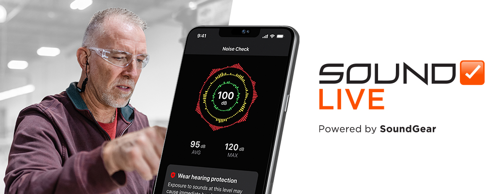 Image of middle aged male wearing SoundGear Phantom hearing protection at work beside a large mobile phone screen showing SoundCheck Live app